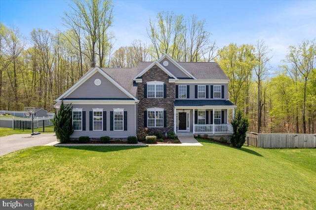 1230 Fairwood Dr, Huntingtown, MD 20639 - view of front of property featuring stone siding, fence, covered porch, and a front yard