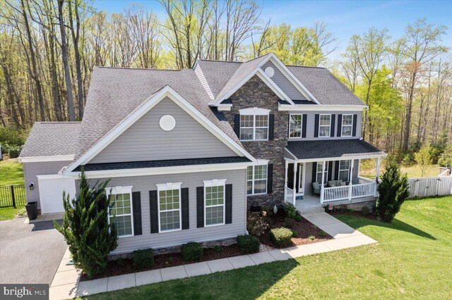 1230 Fairwood Dr, Huntingtown, MD 20639 - view of front facade with covered porch, a front yard, fence, concrete driveway, and stone siding