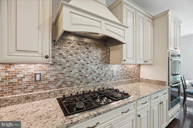 1230 Fairwood Dr, Huntingtown, MD 20639 - kitchen featuring light stone countertops, stainless steel double oven, black gas stovetop, premium range hood, and backsplash