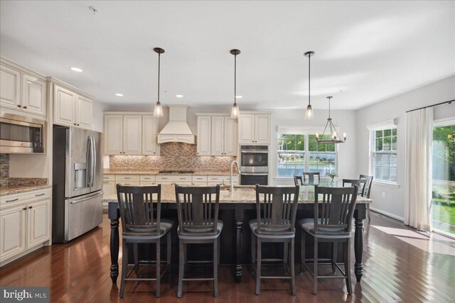 1230 Fairwood Dr, Huntingtown, MD 20639 - kitchen featuring stainless steel appliances, cream cabinetry, custom range hood, and tasteful backsplash
