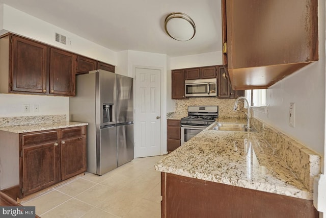 9403 Robin Lee Ct, Manassas Park, VA 20111 - kitchen featuring appliances with stainless steel finishes, a sink, light stone counters, and light tile patterned floors