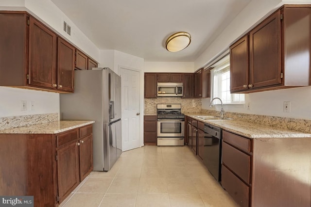 9403 Robin Lee Ct, Manassas Park, VA 20111 - kitchen with stainless steel appliances, a sink, light tile patterned floors, and light stone counters