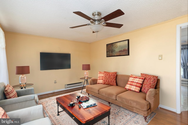 living room featuring baseboards, a baseboard radiator, a ceiling fan, and wood finished floors