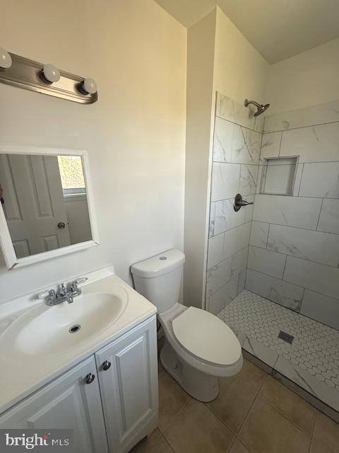 17 Rozina Ct, Owings Mills, MD 21117 - bathroom featuring a tile shower, vanity, tile patterned flooring, and toilet