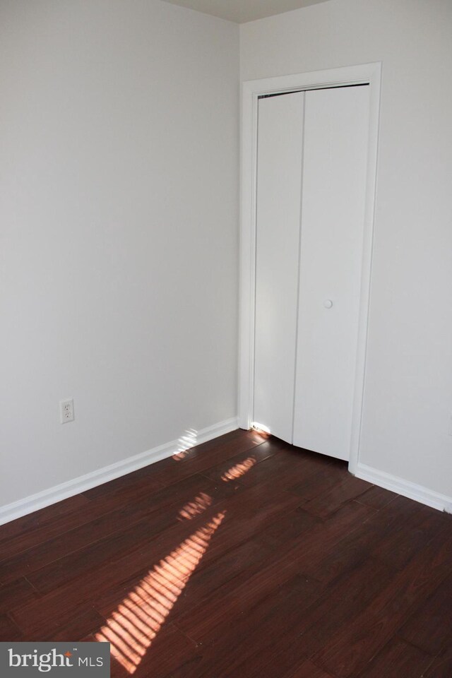 17 Rozina Ct, Owings Mills, MD 21117 - unfurnished bedroom with a closet, baseboards, and dark wood finished floors