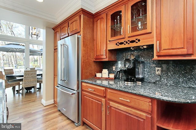 6704 Emporia Ct, Springfield, VA 22152 - kitchen with high end fridge, crown molding, decorative backsplash, brown cabinetry, and dark stone countertops
