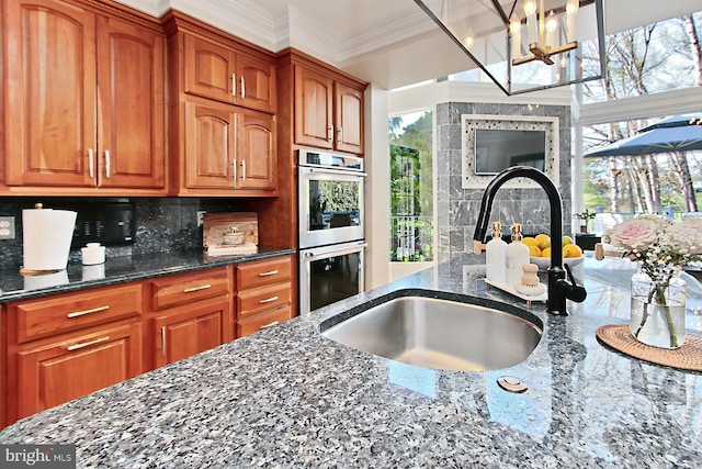 6704 Emporia Ct, Springfield, VA 22152 - kitchen featuring a sink, dark stone countertops, ornamental molding, brown cabinetry, and double oven