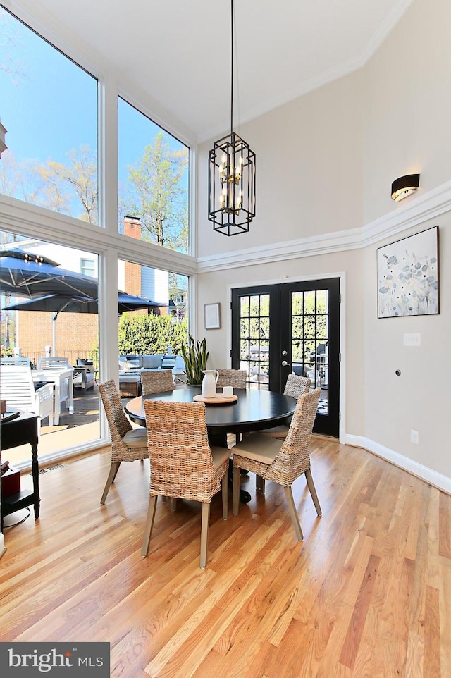 6704 Emporia Ct, Springfield, VA 22152 - dining space featuring a high ceiling, french doors, light wood-style floors, a chandelier, and baseboards