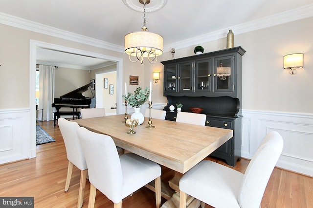 6704 Emporia Ct, Springfield, VA 22152 - dining area with a wainscoted wall, crown molding, light wood finished floors, a chandelier, and a decorative wall