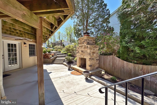 6704 Emporia Ct, Springfield, VA 22152 - view of patio with an outdoor stone fireplace and fence
