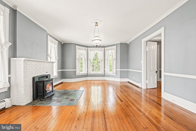 unfurnished living room featuring a wood stove, a baseboard radiator, and hardwood / wood-style floors