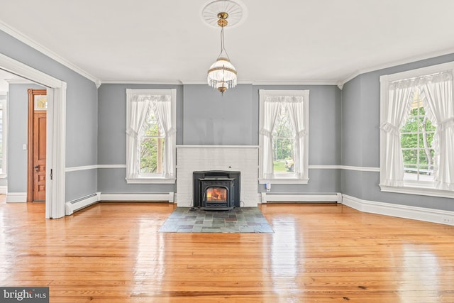unfurnished living room with baseboard heating, plenty of natural light, wood-type flooring, and a baseboard heating unit
