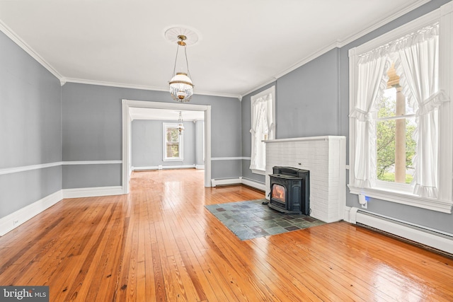 unfurnished living room featuring a baseboard heating unit, a wood stove, hardwood / wood-style floors, and a baseboard radiator