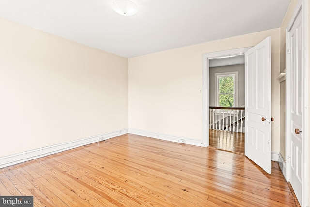empty room featuring baseboards and light wood-style floors