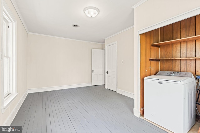 clothes washing area featuring wood-type flooring, laundry area, baseboards, washer / clothes dryer, and ornamental molding