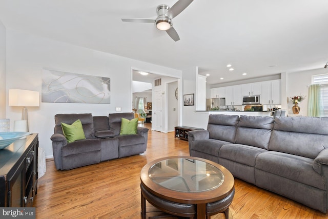 living area with a ceiling fan, light wood-type flooring, and recessed lighting