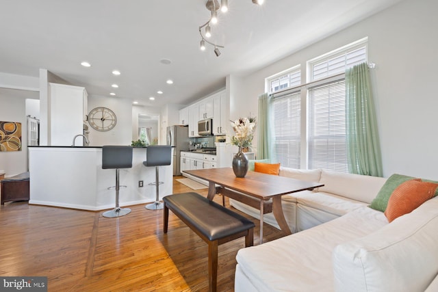 dining room with light wood finished floors and recessed lighting