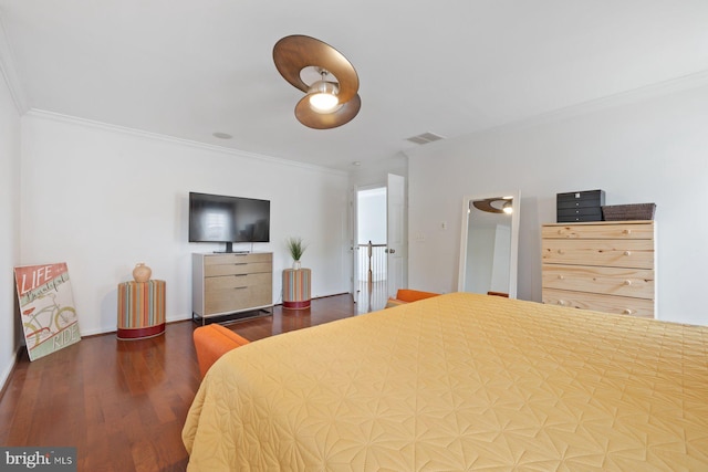 bedroom with crown molding and wood finished floors