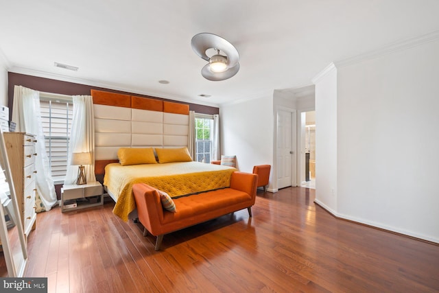 bedroom with ornamental molding, wood finished floors, and baseboards