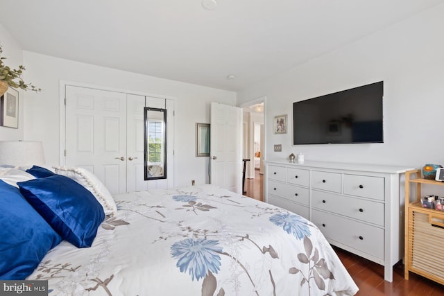 bedroom with dark wood-style floors and a closet