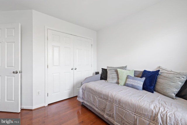 bedroom featuring wood finished floors, a closet, and baseboards