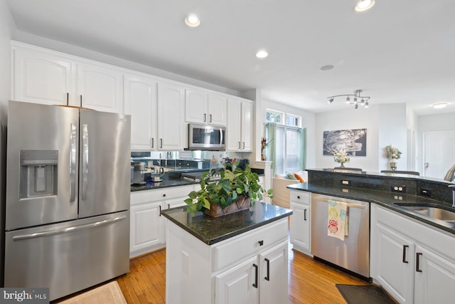 kitchen featuring stainless steel appliances, a sink, white cabinetry, and recessed lighting