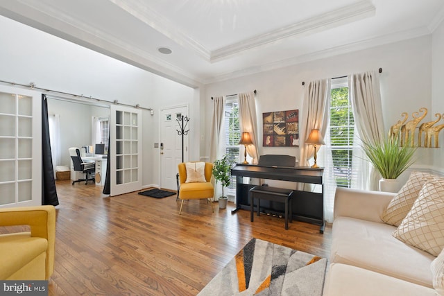 living area featuring a desk, hardwood / wood-style flooring, crown molding, and a tray ceiling