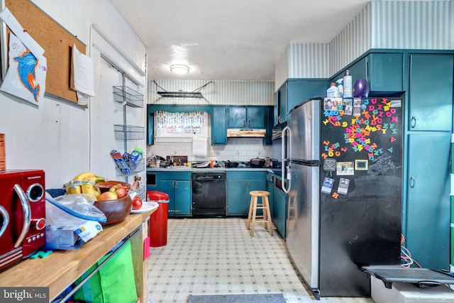kitchen featuring blue cabinets, freestanding refrigerator, black dishwasher, light floors, and under cabinet range hood