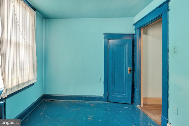 spare room with baseboards, concrete flooring, and a wealth of natural light