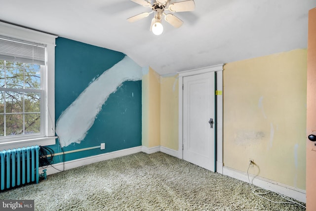 additional living space with a ceiling fan, radiator heating unit, baseboards, lofted ceiling, and carpet flooring