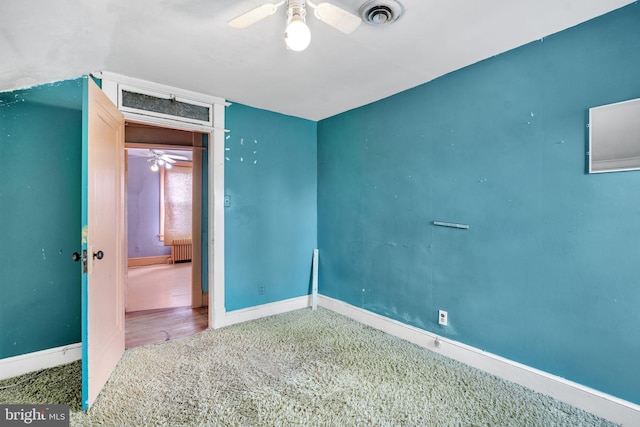unfurnished bedroom with ceiling fan, radiator, baseboards, carpet flooring, and visible vents