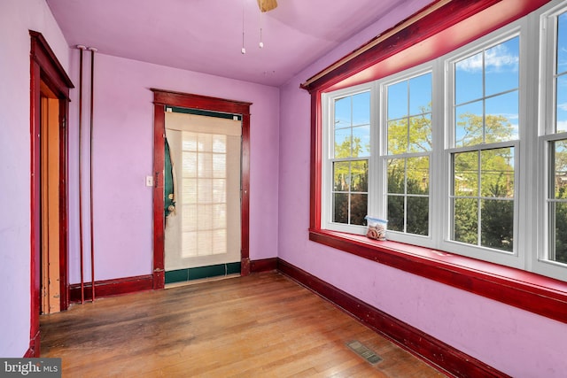 interior space with wood finished floors, visible vents, and baseboards