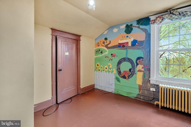 recreation room featuring baseboards, vaulted ceiling, radiator heating unit, and finished concrete flooring