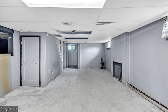 below grade area featuring baseboard heating and a drop ceiling