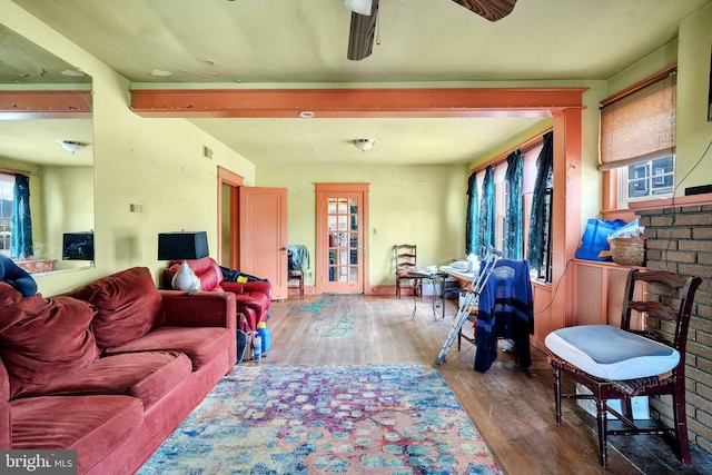 living room with plenty of natural light, a ceiling fan, wood finished floors, and a fireplace