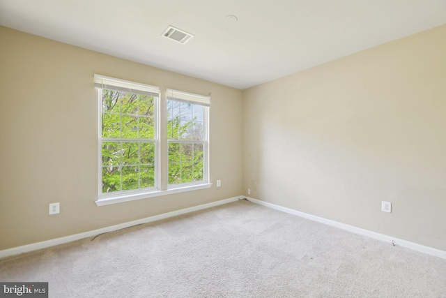 empty room with visible vents, carpet flooring, and baseboards