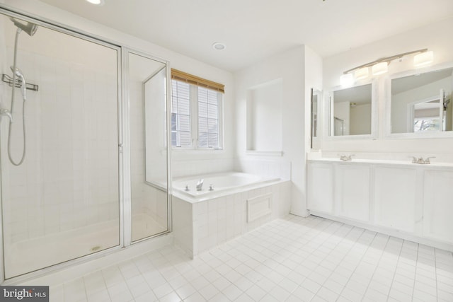 full bath featuring tile patterned floors, a stall shower, a bath, double vanity, and recessed lighting