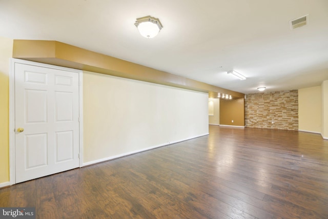 finished basement with baseboards, wood finished floors, and visible vents