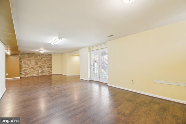 spare room with baseboards and wood finished floors