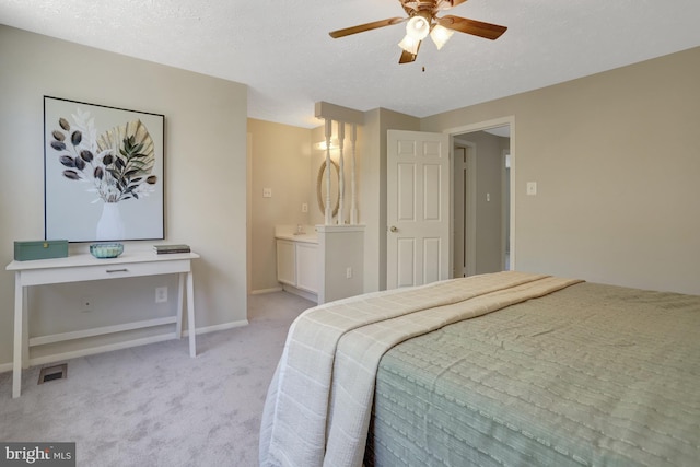 bedroom featuring a textured ceiling, light colored carpet, baseboards, and visible vents
