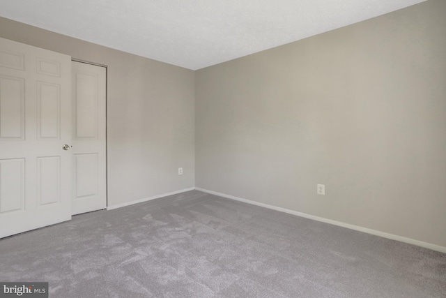 unfurnished bedroom with carpet flooring, baseboards, and a closet