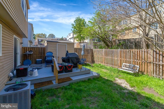 view of yard with a storage shed, a deck, a fenced backyard, cooling unit, and an outdoor structure