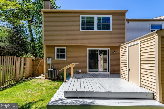 rear view of property with fence, a deck, a gate, a chimney, and central air condition unit