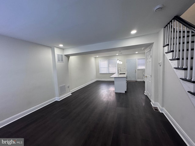 110 N Mount Olivet Ln, Baltimore, MD 21229 - unfurnished living room featuring dark wood-type flooring, visible vents, recessed lighting, and a sink