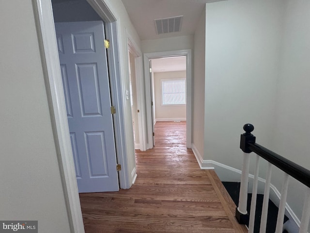 110 N Mount Olivet Ln, Baltimore, MD 21229 - hall featuring wood finished floors, baseboards, visible vents, and an upstairs landing