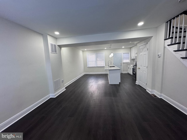 110 N Mount Olivet Ln, Baltimore, MD 21229 - unfurnished living room featuring stairs, dark wood-type flooring, baseboards, and a sink