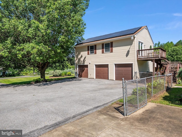 1161 Bacon Ridge Rd, Crownsville, MD 21032 - view of front of house with asphalt driveway, an attached garage, roof mounted solar panels, stairs, and a deck