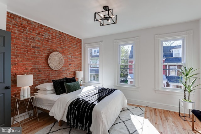 bedroom featuring baseboards, wood finished floors, and multiple windows