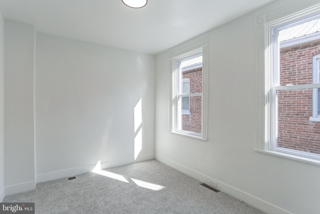 spare room featuring visible vents, carpet flooring, and baseboards