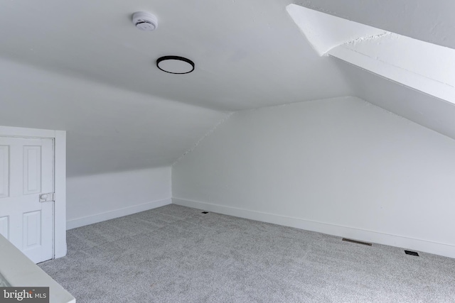 bonus room with lofted ceiling, baseboards, visible vents, and carpet